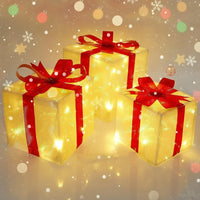 Three illuminated gift boxes with red ribbons on a neutral background